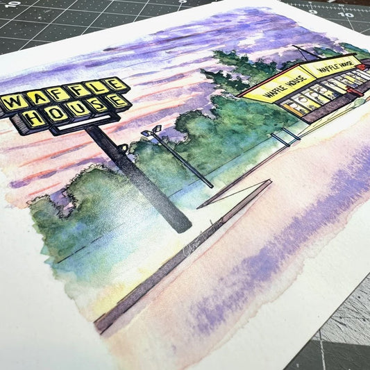Watercolor art print depicting a Waffle House restaurant under a pale pink and blue sky