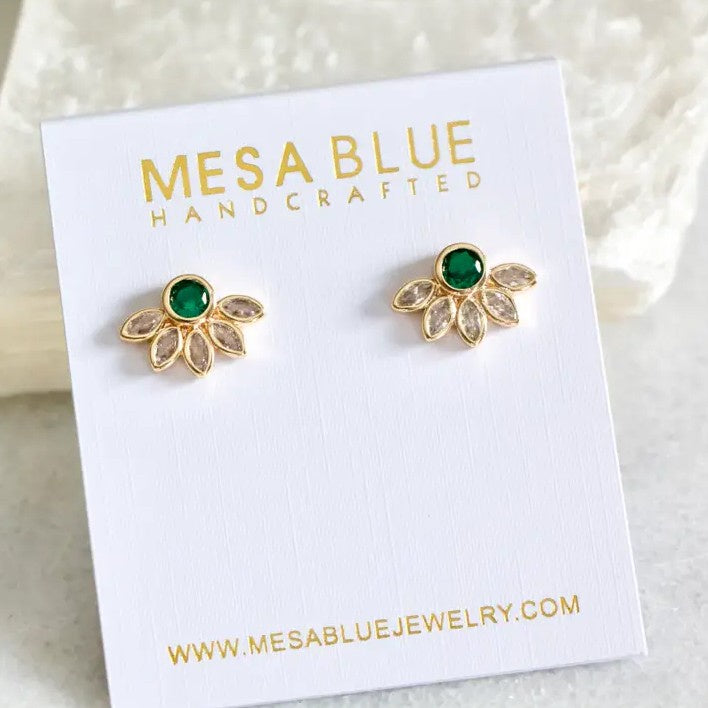 Gold stud earrings with green gemstones surrounded by white crystals in the shape of a flower