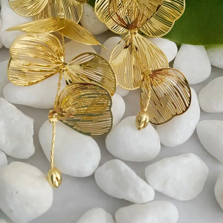 Long gold drop earrings shaped like cascading petals