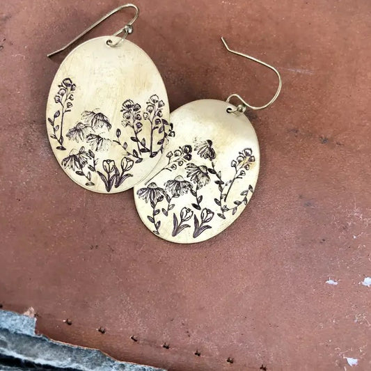 Large dangling brass earrings with wildflowers stamped on them