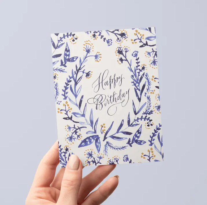 White greeting card with blue and yellow watercolor flowers and the words "Happy Birthday" in elegant calligraphy