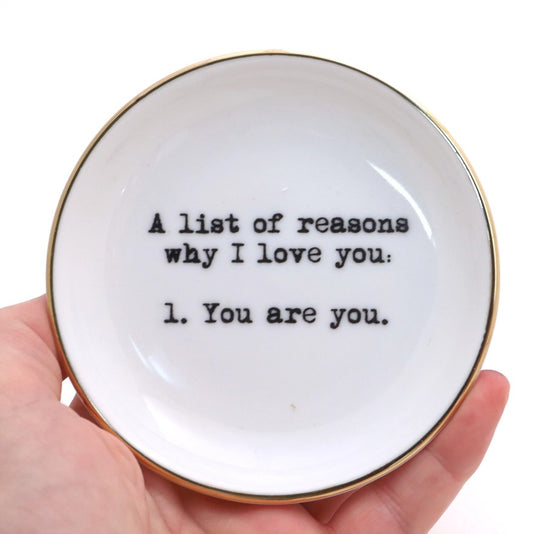 Small white ceramic dish with black text that reads "A list of reasons why I love you: 1. You are you."