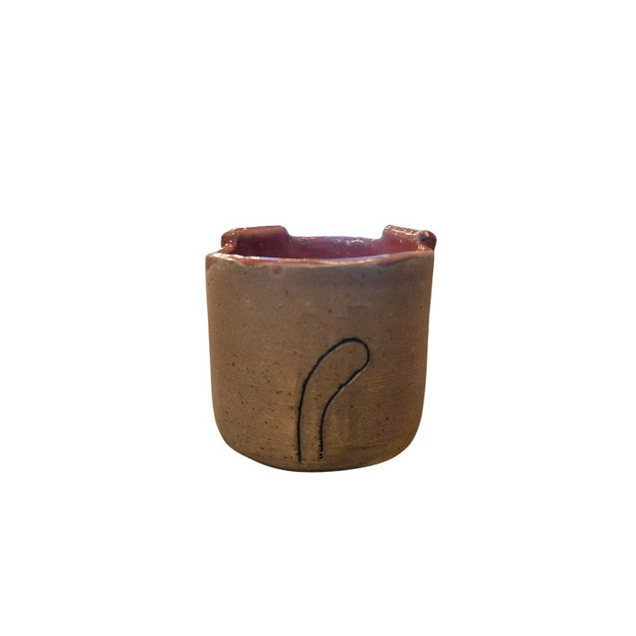 Brown ceramic cup with a tail on the back and pink interior