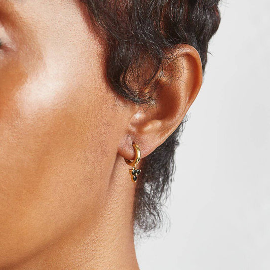 Small gold hoop earrings with three dangling black gems