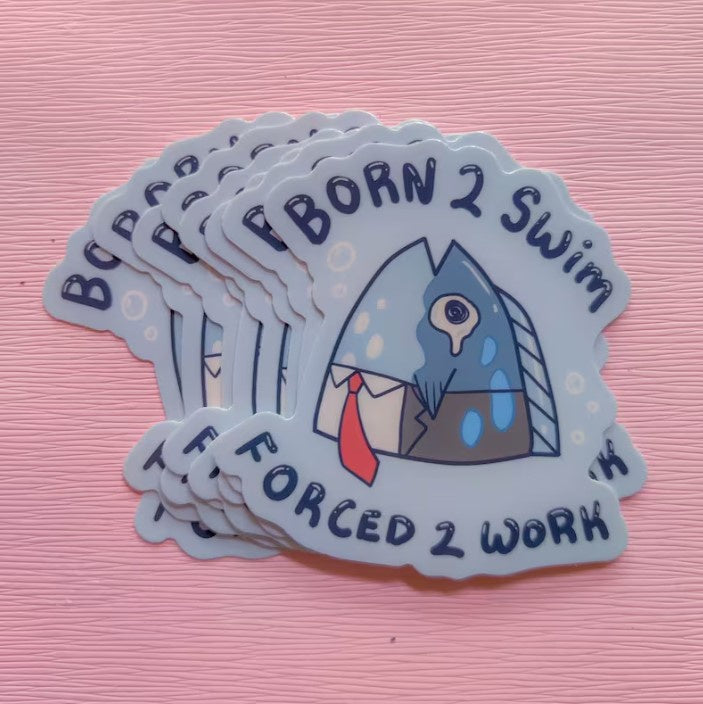 A blue vinyl sticker with a fish wearing a suit and tie captioned "born 2 swim forced 2 work."
