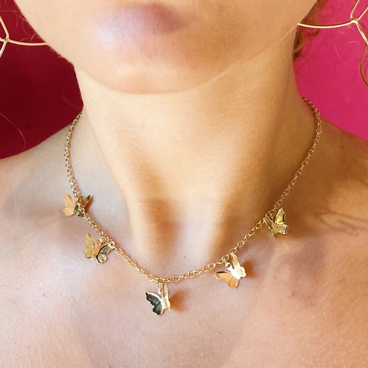 Necklace with five delicate gold butterfly charms in the center