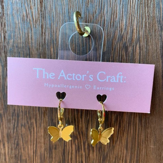 Tiny gold hoop earrings with dangling gold butterfly charms