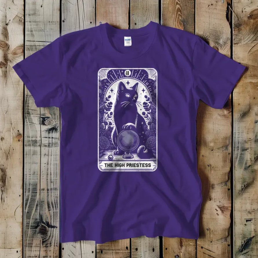Purple tee shirt featuring a tarot card that depicts a cat with a crystal ball and the caption "The High Priestess"