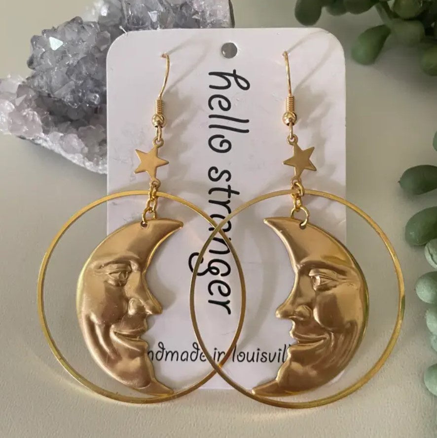 Gold dangle earrings in the shapes of crescent moons with faces