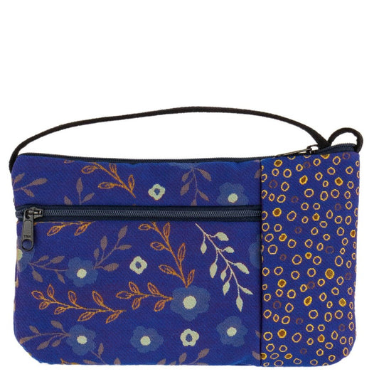 A deep blue hand bag with two delicate mismatched yellow prints. It has a zipper pocket in front and zipper closure at the top.