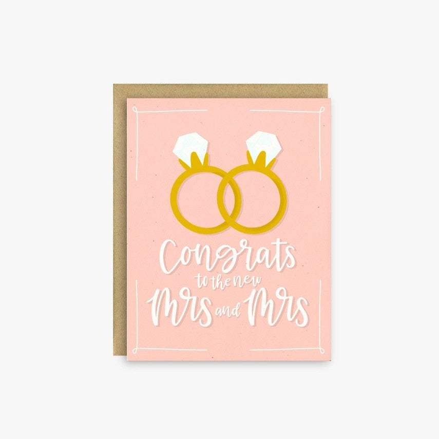 Pink greeting card with two overlapping diamond rings and text that reads "Congrats to the new Mrs. and Mrs."