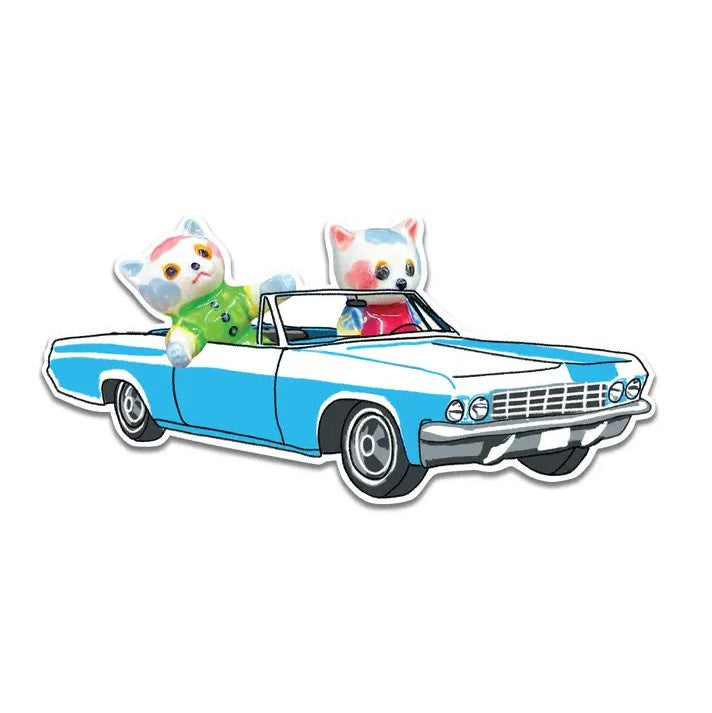 Sticker featuring two white kittens in a blue convertible car