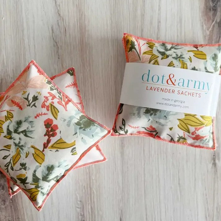 Three square lavender sachets in a pale white, red, yellow and green floral pattern