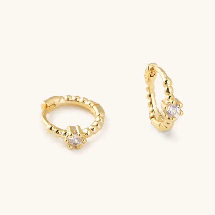 Small gold hoop earrings with a white crystal stone