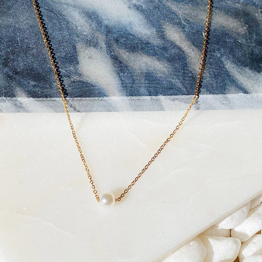 Necklace with a gold chain and small pearl charm