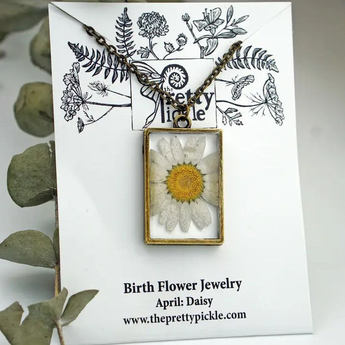 Necklace with a rectangular pendant that showcases a daisy flower in resin