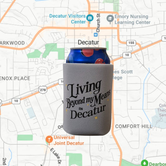 Gray koozie that reads "Living beyond my means in Decatur"