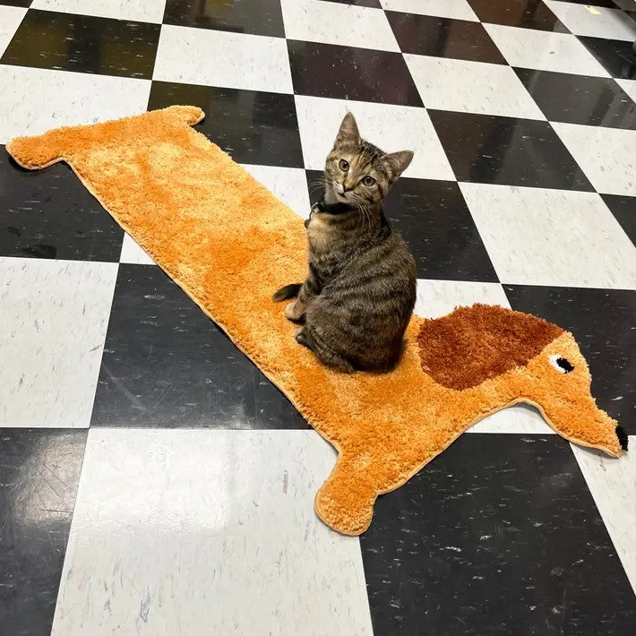 Small light brown rug in the shape of a Dachshund dog