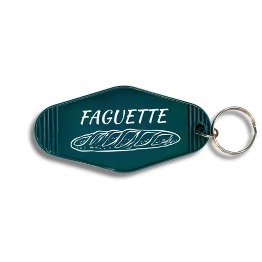 Dark teal keychain with white lettering that reads "Faguette" over an image of a baguette