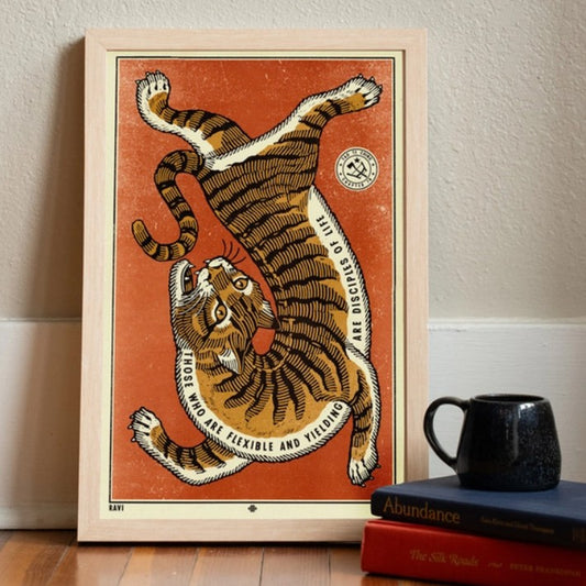 Art print of a tiger twisting before a red background with text along its underbelly reading "Those who are flexible and yielding are disciplines of life"
