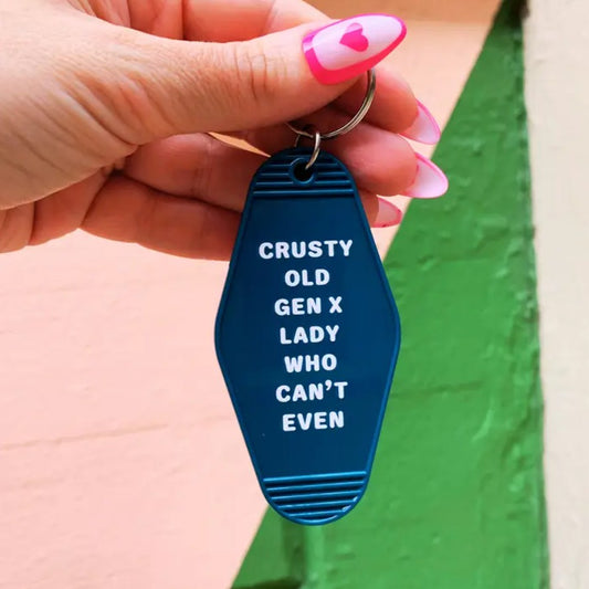 Blue keychain with white lettering that reads "Crusty old gen x lady who can't even"