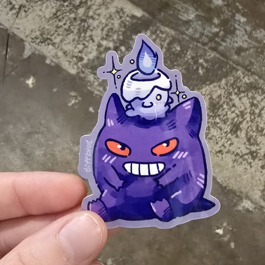 A small purple sticker depicting the Pokémon Gengar and Litwick.