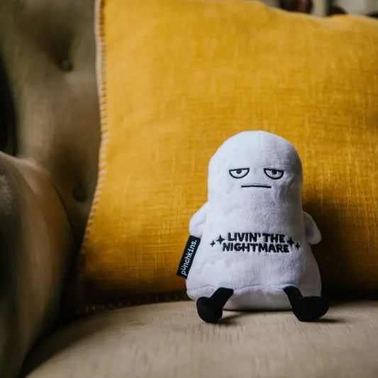 White plush toy in the shape of a ghost with a blank expression and embroidered text that reads "Livin' the nightmare"