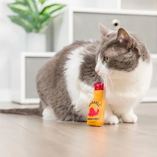 Yellow and red cat toy shaped like a bottle of whiskey