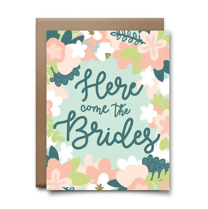 Greeting card with a pastel floral pattern and loopy cursive fond that reads "Here come the Brides"