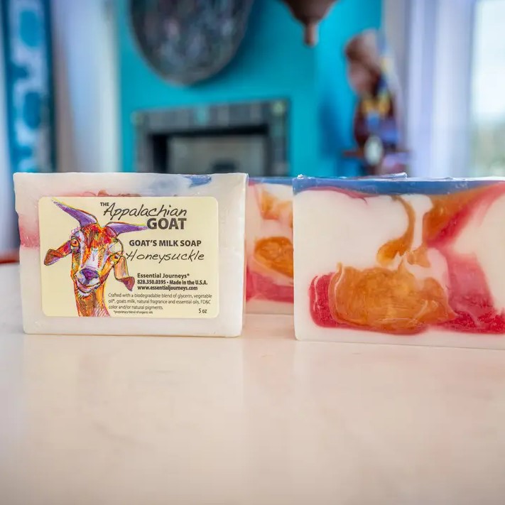 Five ounce honeysuckle scented bar soap with white, orange, red and blue swirls