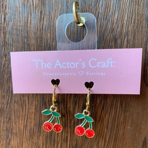 Small gold hoop earrings with red and green dangling cherry charms