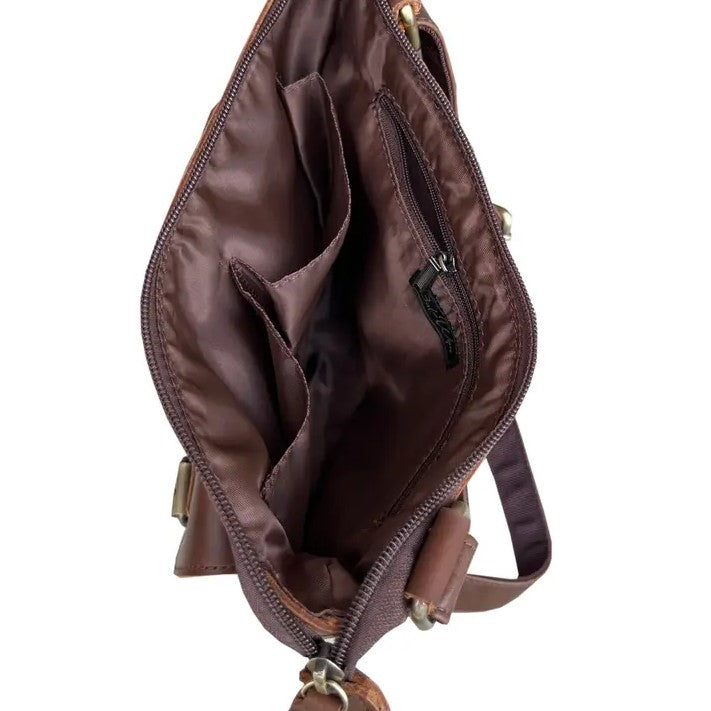 Inside of brown leather bag showing two pockets and one zippered compartment