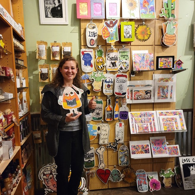 Artist Kandus Johnson holding a candy corn wall art she created