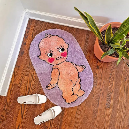 Small lavender rug with the image of a naked smiling kewpie doll on it