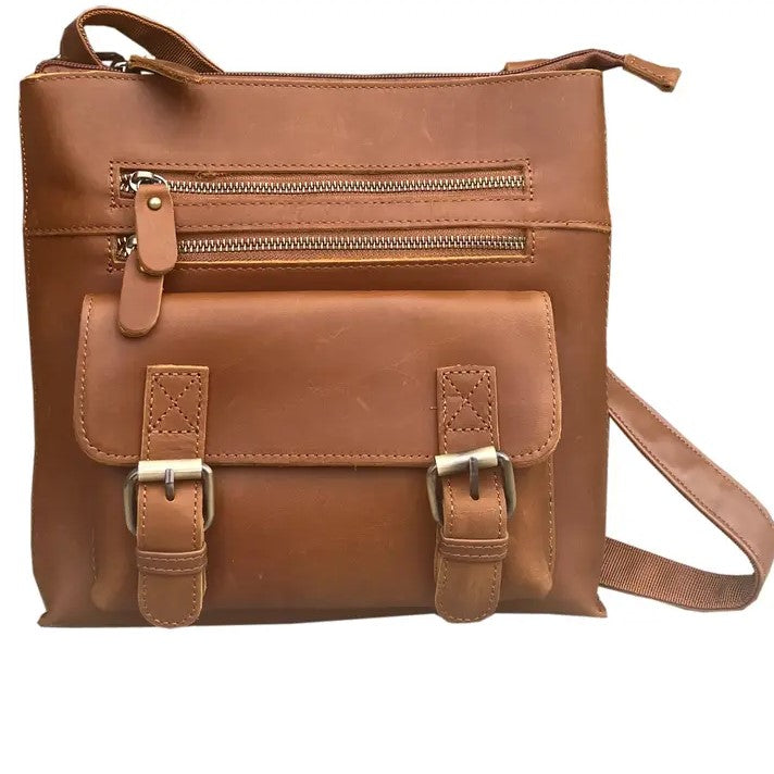 Tan leather crossbody bag with two zippered pockets and a buckled compartment on the front