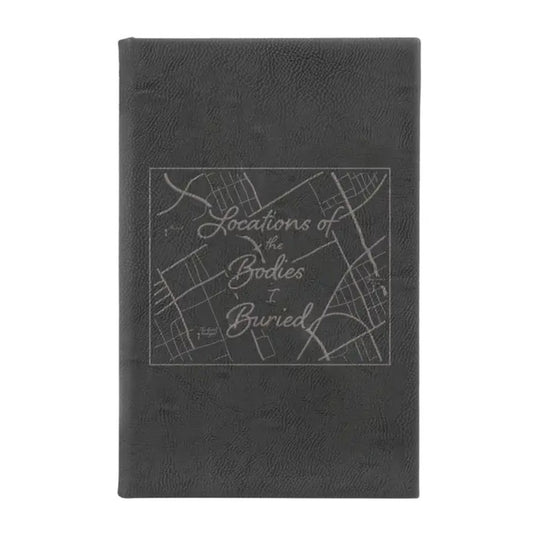 Black leather journal with the words "Locations of the Bodies I Buried" overtop a street map on the cover