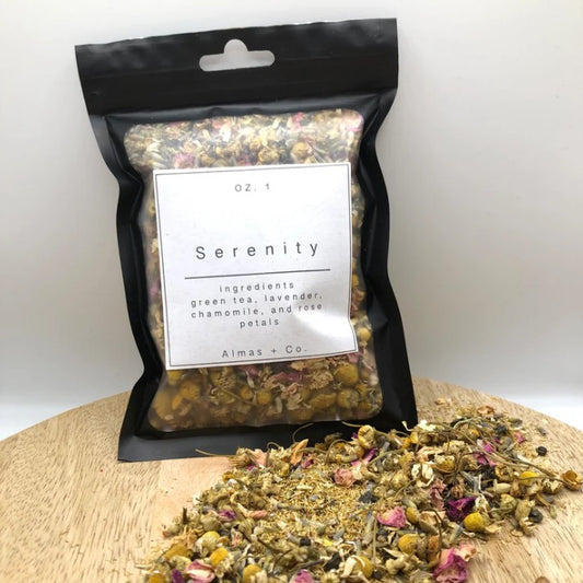 Packaged tea blend labeled 'Serenity' with loose tea on a wooden board.