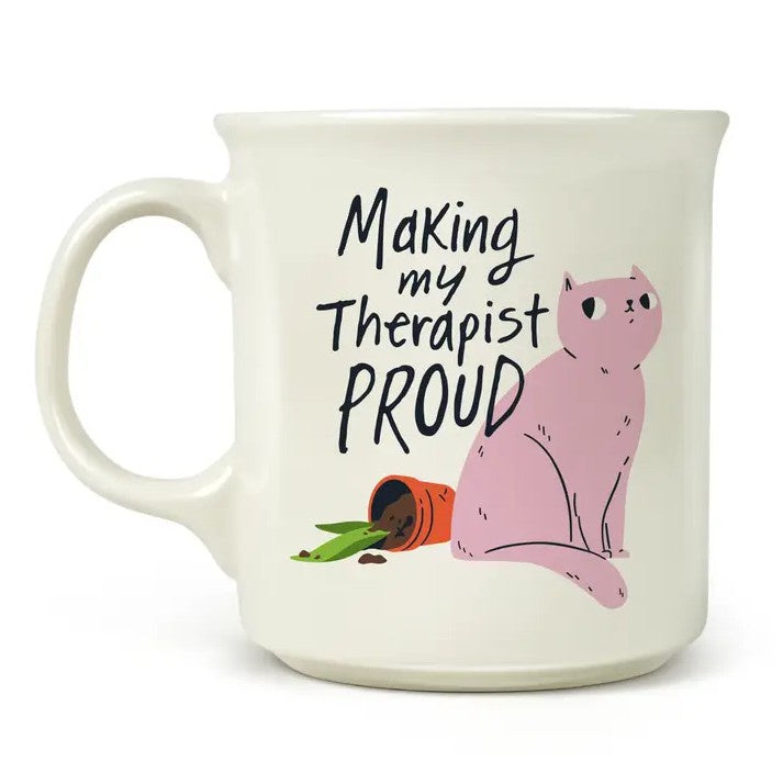 White mug with a pink cat next to a knocked over potted plant and black text that reads "Making my therapist proud"