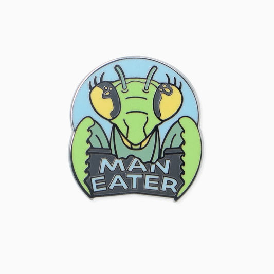 Enamel pin shaped like a praying mantis head with the words "Man Eater" underneath