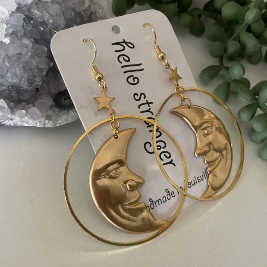 Gold dangle earrings in the shapes of crescent moons with faces
