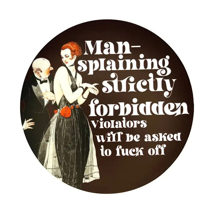 Circular sticker featuring a retro illustration of a man in a suit speaking to a redhead woman in a black dress and the caption "Man-splaining strictly forbidden. Violators will be asked to fuck off"