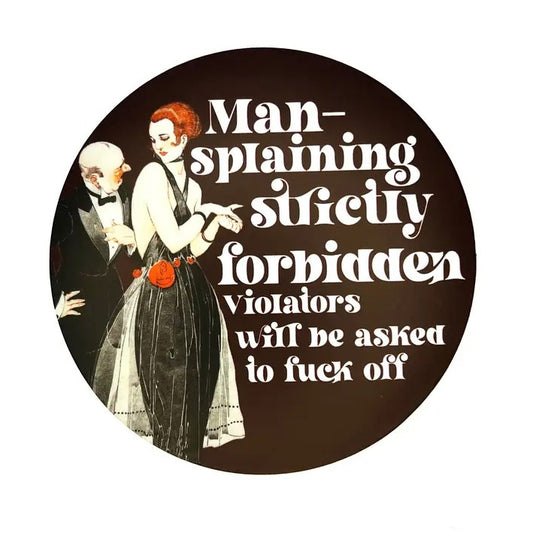 Circular sticker featuring a retro illustration of a man in a suit speaking to a redhead woman in a black dress and the caption "Man-splaining strictly forbidden. Violators will be asked to fuck off"