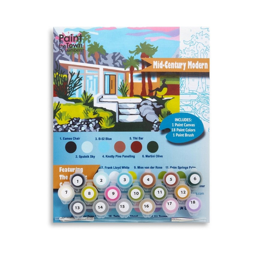 A mid-century modern themed paint by numbers kit depicting a house surrounded by palm trees and mountains. the kit includes one canvas, one paint brush and 18 paint colors.