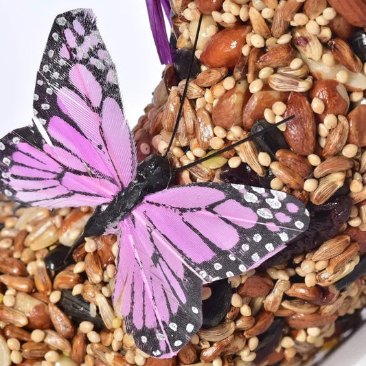 A closeup of a butterfly decal on a seed and nut wreath birdfeeder.