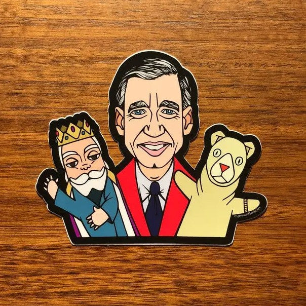 Sticker depicting Mr. Rogers smiling with a puppet on each hand