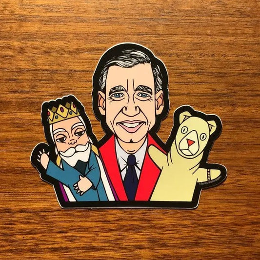 Sticker depicting Mr. Rogers smiling with a puppet on each hand
