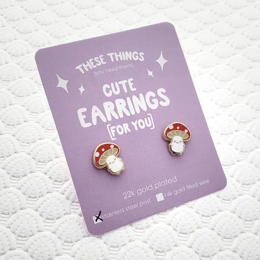 Stud earrings shaped like smiling little mushrooms