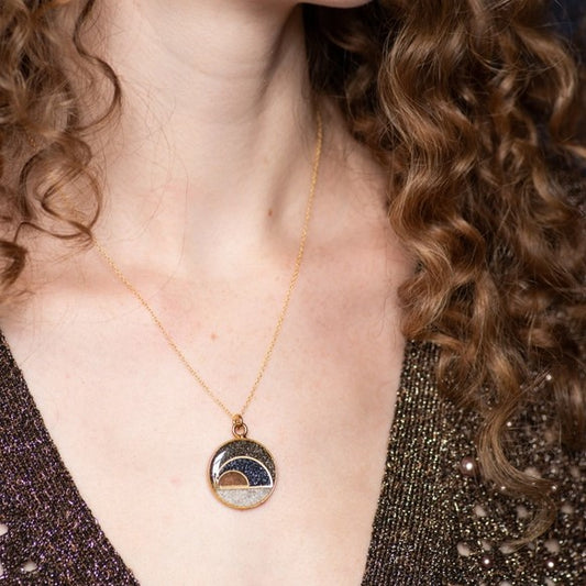 Bronze chain necklace with circular pendant featuring crushed gemstone semi-circles in charcoal, dark blue, bronze and white colors