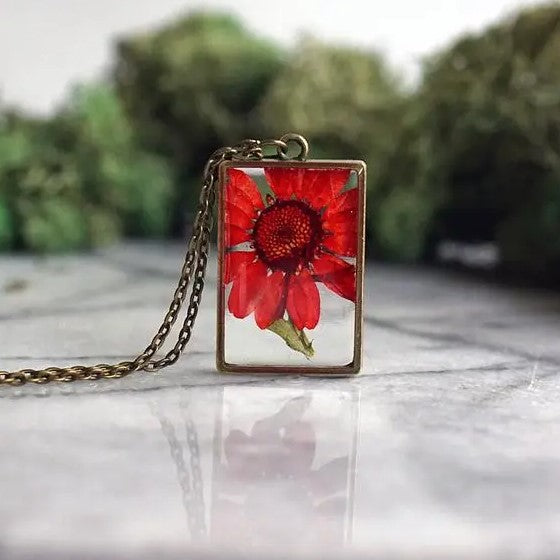 Necklace with a rectangular pendant that showcases a chrysanthemum flower in resin