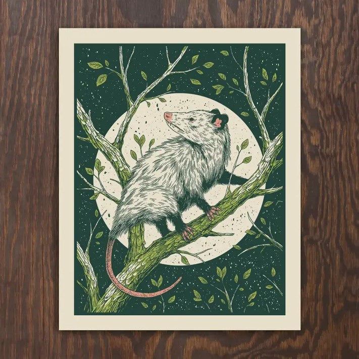 An 8x10 print of a possum climbing a tree branch in front of a full moon and dark green background.